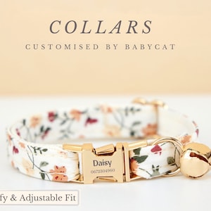 Op de afbeelding: Een witte kattenhalsband met een bloemenpatroon en gouden hardware. De halsband heeft een bel en een gepersonaliseerd naamplaatje met de tekst "Daisy 0672304960". De halsband wordt beschreven als "Comfortabel en verstelbaar".