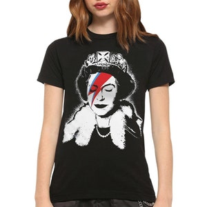 May include: Black t-shirt with a white graphic of Queen Elizabeth II wearing a crown and a blue and red lightning bolt across her eye.