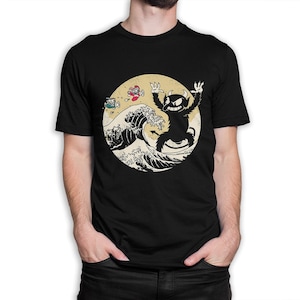 May include: Black t-shirt with a graphic of a cartoon devil riding a wave. The wave is stylized to look like the Great Wave off Kanagawa.