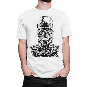 May include: A white t-shirt with a black and white graphic of a robot skull. The robot skull has a menacing expression with a wide open mouth and visible teeth.