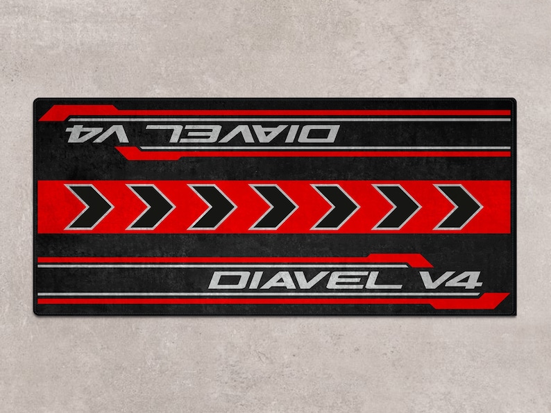 Op de afbeelding: Zwart en rood grafisch ontwerp met de tekst "Diavel V4" die twee keer wordt herhaald. Het ontwerp bevat vijf rode pijlen die naar rechts wijzen.
