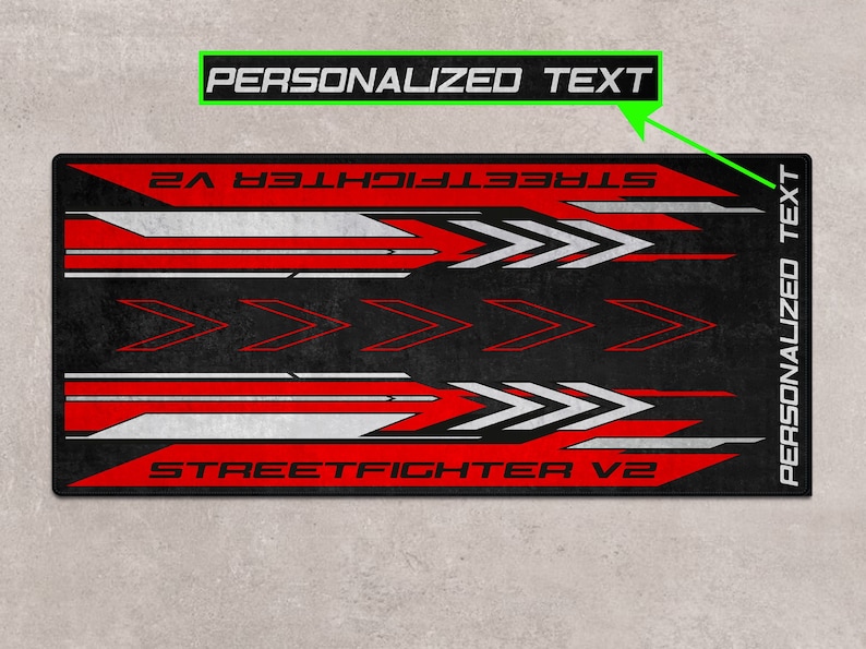 Puede incluir: Alfombrilla de rat&oacute;n para juegos negra y roja con detalles blancos y el texto "STREET FIGHTER V2" y "TEXTO PERSONALIZADO".