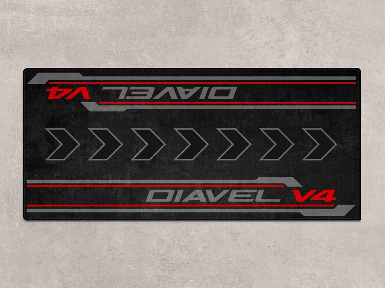 Op de afbeelding: Zwarte en rode motorfiets vloermat met de tekst "Diavel V4" en vijf pijlen die naar rechts wijzen.