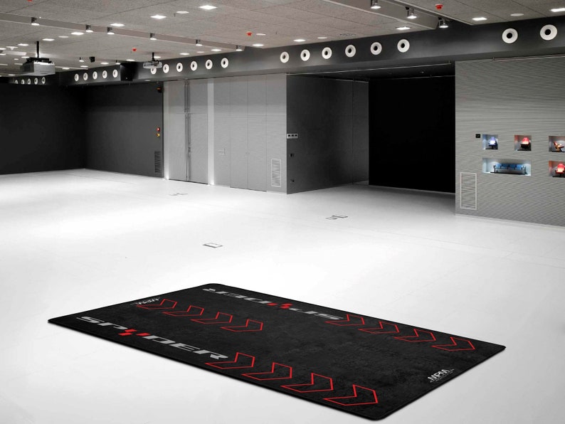 Op de afbeelding: Zwarte trainingsmat met rode pijlen en de tekst "STREET" en "APPA" erop gedrukt.