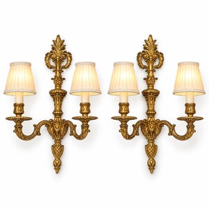 Par de apliques de parede vintage em estilo Luís XV, com dois braços em metal dourado e brasão de acanto.