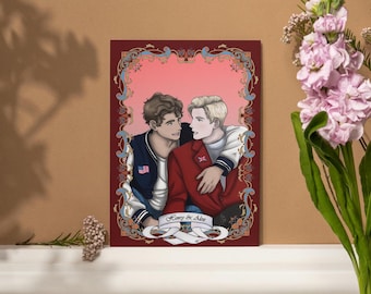 Op de afbeelding: Illustratie van twee mannen die elkaar omarmen, geplaatst in een decoratieve lijst. Eén man draagt een rode jas met een Britse vlagspeld, de ander een blauwe jas met een Amerikaanse vlagpatch. De tekst "Henry & Alex" is zichtbaar.