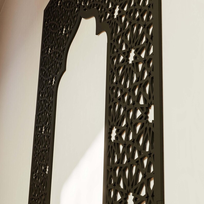 May include: A dark brown, intricately carved wooden decorative panel. The panel features a Moorish arch design with geometric star and diamond patterns. The panel is mounted on a white wall, creating a contrast.