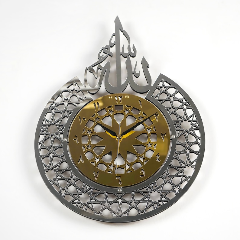 May include: A silver and gold wall clock with an intricate geometric design and the Arabic word "Allah" in the center. The clock face features a gold background with black hands and Roman numerals.