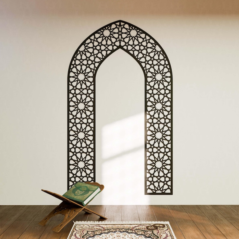May include: A black and white geometric archway wall decal with intricate star and circle patterns. A wooden prayer stand with a green book is in the foreground.