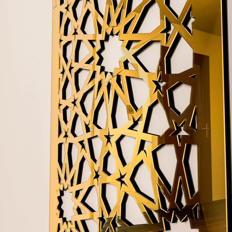 May include: A gold geometric wall panel featuring a repeating star and angular design. The panel is mounted on a white wall, creating a contrast with the gold. The design is intricate and detailed, with a modern aesthetic.