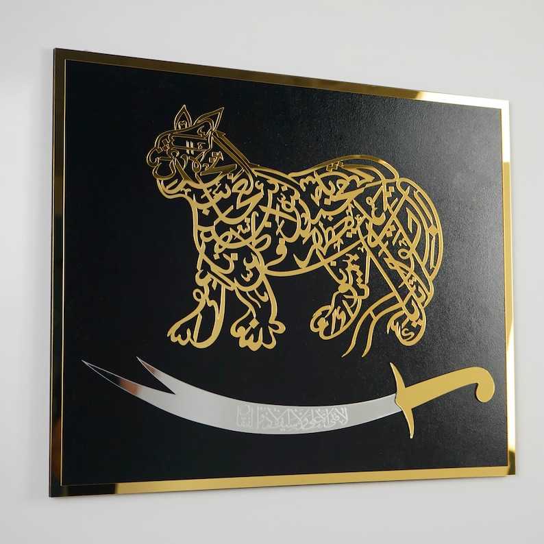 Puede incluir: Una pieza de arte de pared enmarcada en negro con un dise&ntilde;o met&aacute;lico dorado de un le&oacute;n estilizado con una espada. El le&oacute;n est&aacute; hecho de caligraf&iacute;a &aacute;rabe.