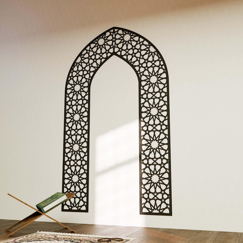 May include: A black and white geometric archway wall decal with a traditional Islamic design. The decal is applied to a white wall and features a repeating pattern of stars and geometric shapes.