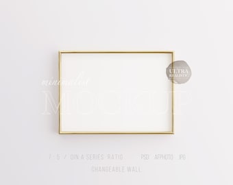 May include: A gold-colored frame mockup on a white wall. The frame is rectangular and has a minimalist design. The text "minimalist MOCKUP" is visible in the image.
