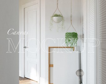 Könnte beinhalten: Ein weißer Leinwand-Mockup, der an einer weißen Wand mit einem Holzrahmen lehnt. Im Hintergrund befinden sich zwei Hängepflanzen mit grünen Blättern. Der Text "Canvas Mockup" ist in Weiß an die Wand geschrieben.
