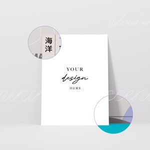 May include: A white card mockup with the text "YOUR design HERE" in black script font. The card is sitting on a light gray surface with a blue, gray, and white abstract design in the background.