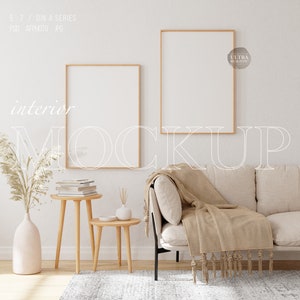 May include: An interior mockup scene with two framed blank art prints above a beige sofa with a tan throw. A small wooden side table holds books and a vase with dried plants. The text "interior MOCKUP" is overlaid on the image.
