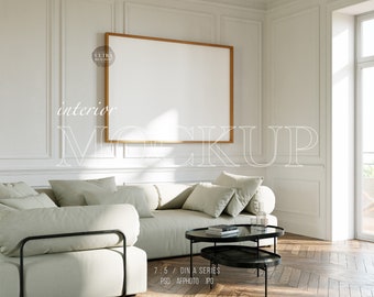 Può includere: Un divano componibile bianco con cuscini grigio chiaro si trova in un soggiorno moderno con un grande quadro incorniciato appeso al muro. Un tavolino da caffè nero a due livelli si trova di fronte al divano. La stanza ha pareti bianche e un pavimento in legno.
