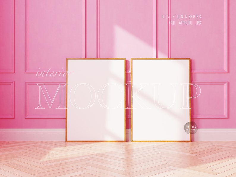May include: Two gold framed picture frames with white mats are hanging on a pink wall with white trim. The frames are empty and ready for your photos or artwork.  The frames are in a room with a wood floor.