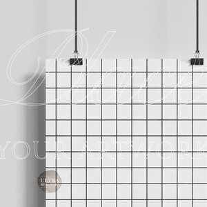 May include: A white poster with a black grid pattern hanging from the ceiling with black clips. The poster is blank and ready for your artwork.