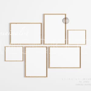 Peut inclure: Cinq cadres photo en bois de différentes tailles sont disposés sur un mur blanc. Les cadres sont tous vides et ont une finition en bois naturel.
