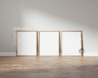 May include: Three wooden picture frames with white mats, hanging on a white wall. The frames are arranged in a row, with the middle frame slightly higher than the other two. The frames are empty, ready for your photos or artwork.