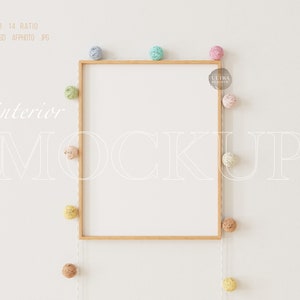 Puede incluir: Una maqueta de marco de madera con fondo blanco. El marco está rodeado de una cuerda de bolas de hilo de colores.
