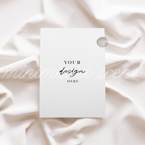 May include: A white card with the text "YOUR design HERE" on a white fabric background.