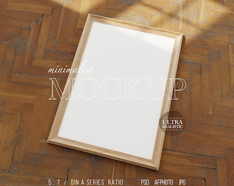 May include: A wooden frame mockup with a white background. The frame is on a wooden floor with a shadow from a light source above. The text "minimalist MOCKUP" is visible in the image. The text "ULTRA REALISTIC" is also visible in the image. The text "5:7 DIN A SERIES RATIO PSD AFPHOTO JPG CHANGEABLE WALL" is visible at the bottom of the image.
