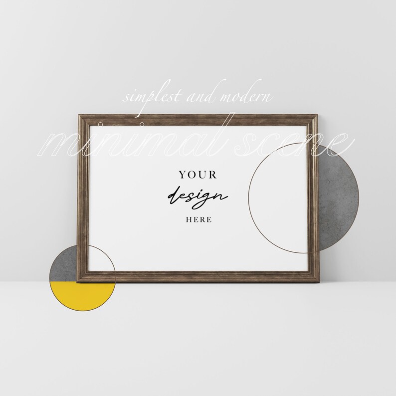 May include: A brown wooden frame with a white background and the text "YOUR design HERE" inside. The frame is on a white surface with two gray and yellow circles.