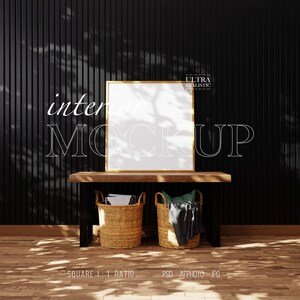 May include: A square picture mockup with a gold frame, positioned on a wooden shelf with two woven baskets on either side. The shelf is set against a black wall with vertical grooves. The text "interior mockup" is in white letters on the wall.