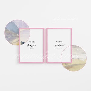 May include: Two pink picture frames with white mats on a white wall. The frames are empty and have the text "Your design here" written in black inside each frame.