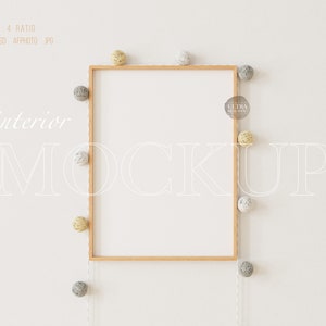 Puede incluir: Una maqueta de marco de madera con fondo blanco, rodeada de una cadena de luces decorativas de bolas de algodón en tonos grises y amarillos.