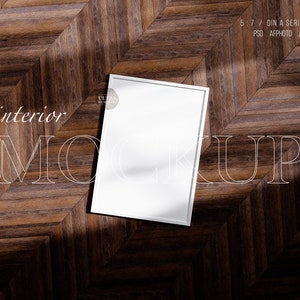 May include: White frame mockup on a brown wood floor with a herringbone pattern. The text "interior mockup" is written in white on the floor.