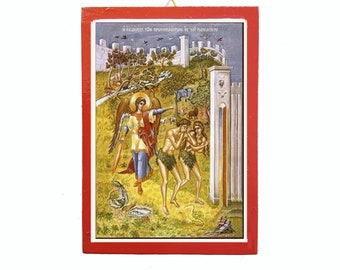 May include: A framed religious icon with a red border. The image depicts a biblical scene with an angel, Adam, Eve, and various animals. The background shows a white wall and trees.
