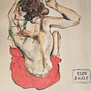 Peut inclure: Une figure nue d'une personne aux cheveux bruns, assise dos au spectateur, portant une jupe rouge. La figure a les bras levés au-dessus de sa tête. La signature de l'artiste, "EGON SCHIELE", est dans le coin inférieur droit de l'image.