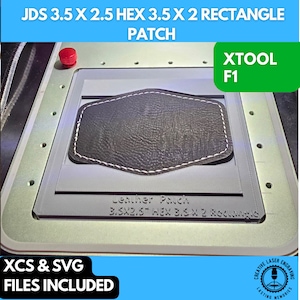 May include: A gray leather patch is placed in a white plastic frame with the text "Leather Patch 3.5X2.5" HEX 3.5 X 2 Rectangle" printed on the frame. The frame is labeled "XTOOL F1" in the top right corner. The text "XCS & SVG FILES INCLUDED" is printed in the bottom left corner. The text "CREATIVE LASER ENGRAVING LASTING MEMORIES" is printed in a circle in the bottom right corner.
