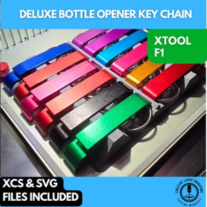 May include: A variety of colorful bottle opener keychains are displayed in a white tray. The keychains are made of metal and have a sleek, modern design. The text "XTOOL F1" is visible in the top right corner of the image. The text "XCS & SVG FILES INCLUDED" is visible in the bottom left corner of the image.