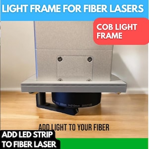 May include: A white light frame for fiber lasers with the text "COB LIGHT FRAME" in red letters. The frame is mounted on a wooden surface and a black lens is attached to the bottom of the frame. The text "ADD LED STRIP TO FIBER LASER" is written in green letters at the bottom of the image.