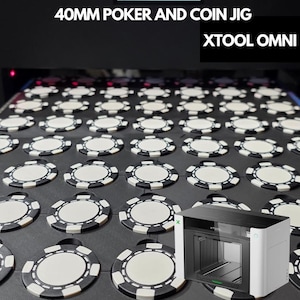 May include: A black 40mm poker and coin jig for Xtool Omni featuring a grid of circular cutouts holding white and black poker chips. The jig is a flat, rectangular board with uniform spacing for multiple chips, designed for laser engraving.