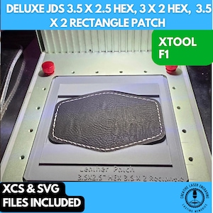 May include: A close-up of a gray leather patch with white stitching, resting in a gray plastic mold. The mold is labeled "Leather Pouch 3.5x2.5" HEX 3.5 x 2 Rectangle". The image also includes the text "DELUXE JDS 3.5 X 2.5 HEX, 3 X 2 HEX, 3.5 X 2 RECTANGLE PATCH" and "XTOOL F1".