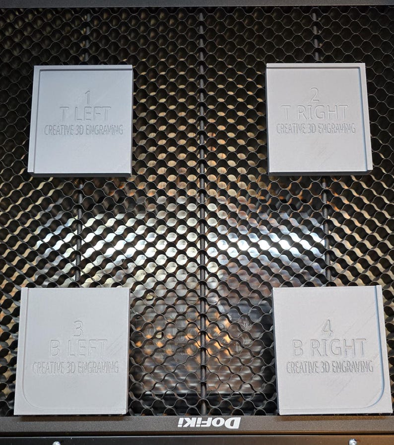 May include: Four gray square plaques with rounded corners, each with a number and text. The plaques are labeled "1 T LEFT CREATIVE 3D ENGRAVING", "2 T RIGHT CREATIVE 3D ENGRAVING", "3 B LEFT CREATIVE 3D ENGRAVING", and "4 B RIGHT CREATIVE 3D ENGRAVING". The plaques are arranged in a grid pattern on a black metal surface.
