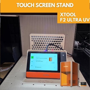 May include: A touch screen stand with the text "TOUCH SCREEN STAND" at the top. The stand has a screen displaying information, with the text "XTOOL F2 ULTRA UV" on the stand and a small orange box. A small orange box is on the right.