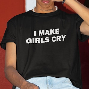 May include: A black t-shirt with white text that reads "I MAKE GIRLS CRY".