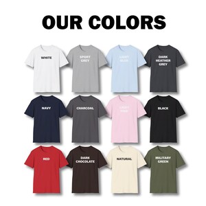 May include: A chart of 12 t-shirts in different colors, including white, sport grey, light blue, dark heather grey, navy, charcoal, light pink, black, red, dark chocolate, natural, and military green. The t-shirts are all the same style and have the color name printed on the front.
