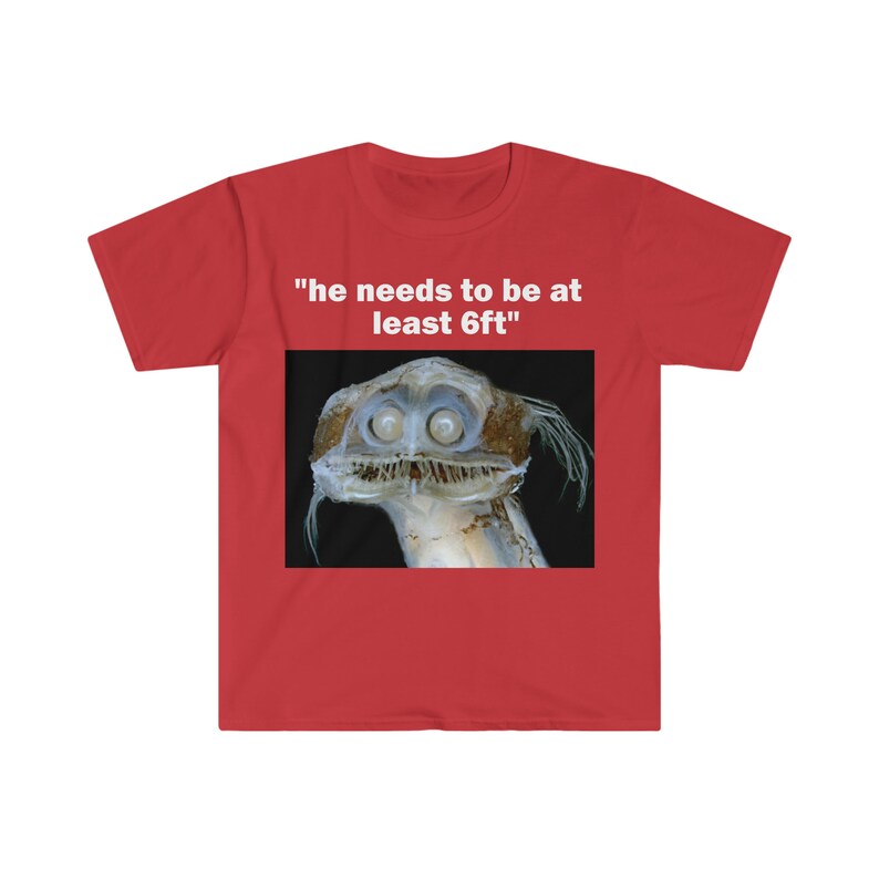 Puede incluir: Camiseta roja con un gr&aacute;fico blanco de una criatura de aguas profundas con el texto "tiene que medir al menos 6 pies"