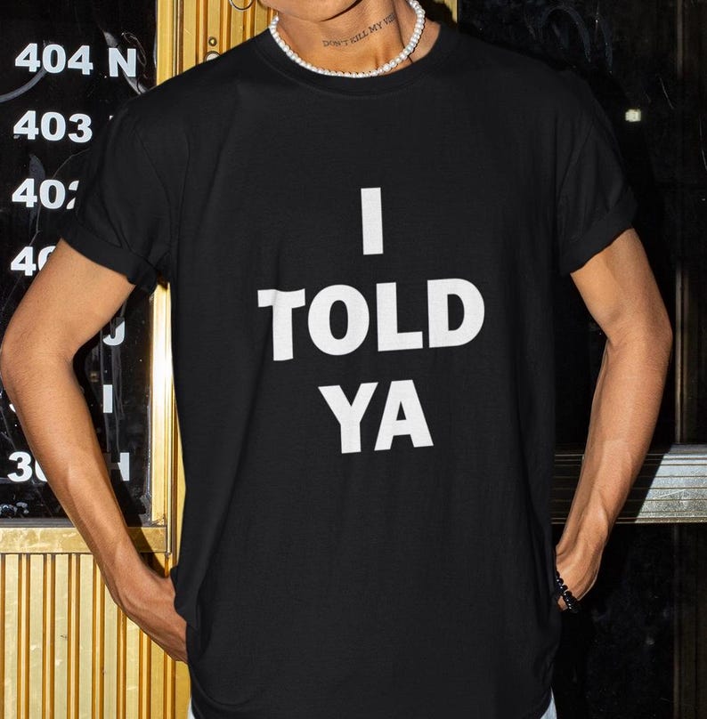 May include: A black t-shirt with white text that reads "I TOLD YA".