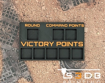 May include: Black and orange plastic tracker for a board game. It has spaces for tracking round, command points, and victory points.