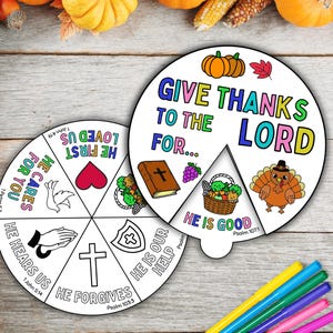 May include: Two Thanksgiving-themed paper crafts with the text "Give Thanks to the Lord For..." and "He is Good." One craft has a turkey, pumpkins, and a leaf. The other has a heart, dove, and cross.