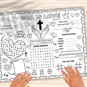 May include: A white activity sheet with the words "GOD IS LOVE" and various activities, including a maze, word search, and tic-tac-toe. The sheet also features the text "you are loved" and "Jesus loves you". A yellow pencil rests on the right side.
