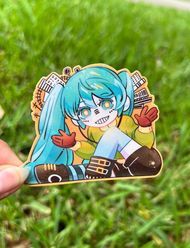 May include: A colorful sticker featuring an anime-style character with turquoise pigtails, orange eyes, and a stitched mouth. The character wears a yellow top, blue shorts, and brown boots. The sticker has a cityscape design and red gloves.